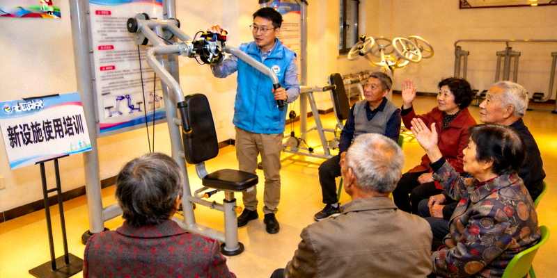 社区居民参加新设施使用培训活动 - 指导员正在讲解器材使用方法