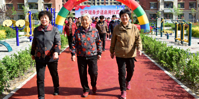 社区健身步道启用仪式 - 居民在崭新的塑胶步道上健走