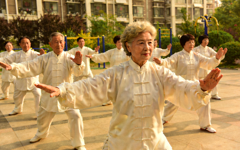 社区体育节活动 - 社区居民在广场上一起练习太极拳