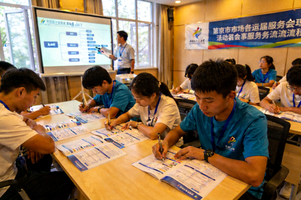 志愿者培训现场，年轻志愿者认真学习赛事服务流程
