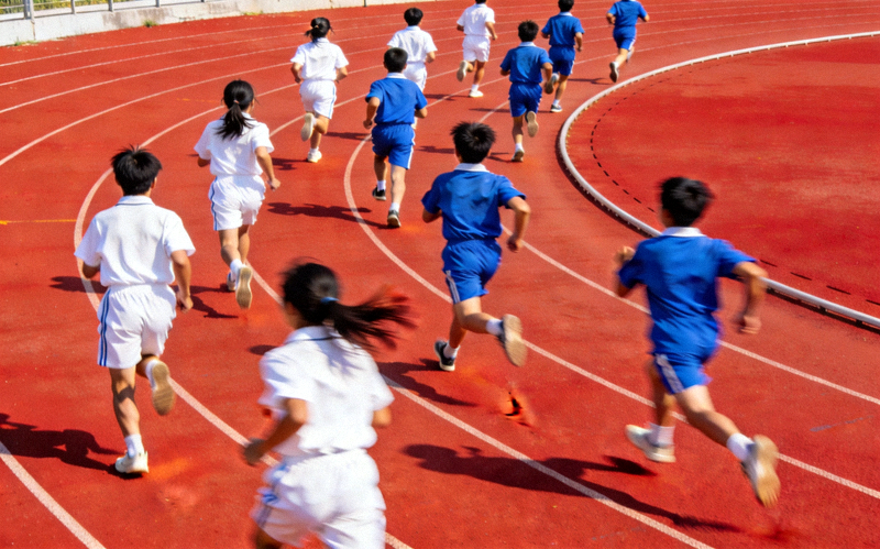 田径场上的青少年奔跑 - 学生们在红色跑道上进行速度训练
