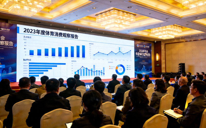 体育消费观察报告发布现场配图 - 会场大屏幕上展示年度体育数据与图表，观众正在聆听