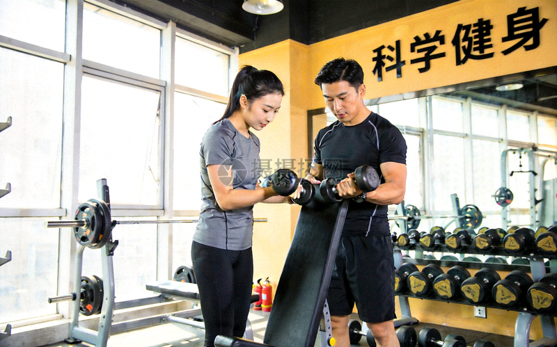 健身教练在明亮的健身房内指导学员进行力量训练，展现科学健身场景